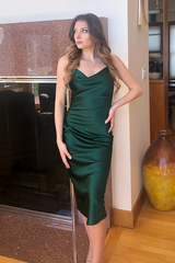 Woman wearing a green satin dress in an indoor setting