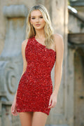 Woman wearing a red sequin dress standing outdoors with a blurred background