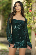 Woman wearing a green sequin dress with a blurred outdoor background