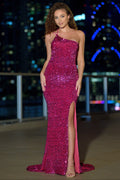 Woman in a pink sequin dress with a high slit standing against a cityscape background.